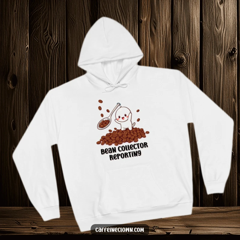 Funny hoodie featuring a playful character using a giant spoon to catch falling coffee beans, combining warmth and humor.