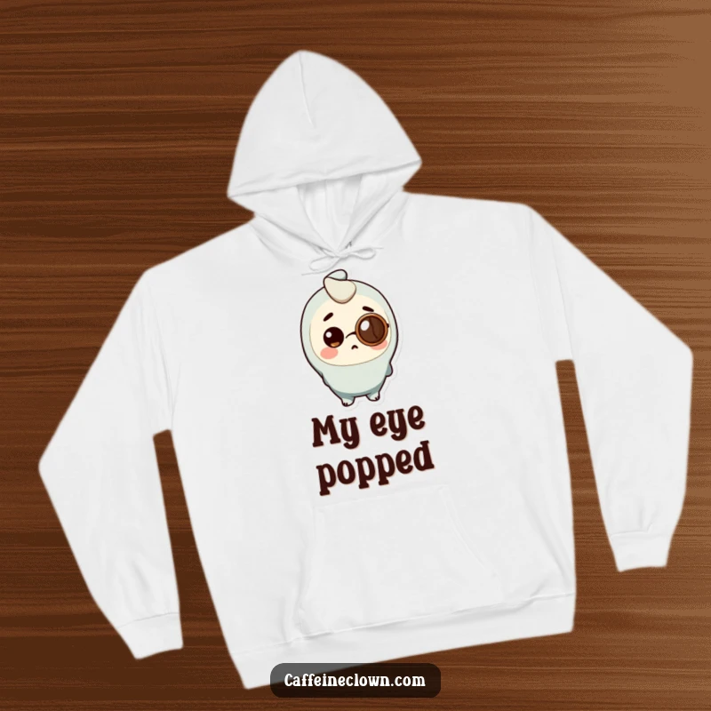Funny Hoodie showing a character wearing a coffee bean as a monocle, looking very surprised, for cozy wear.